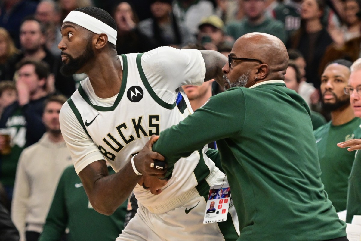 Milwaukee Bucks forward Bobby Portis (9) is restrained by a coach 